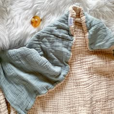 an unmade baby sleeping bag on top of a white blanket