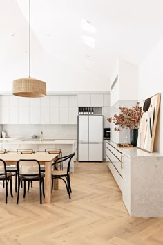 an image of a kitchen with white cabinets and black chairs on the dining room table