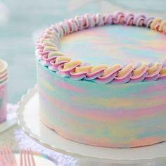 there is a cake with pastel icing on it and two forks next to it