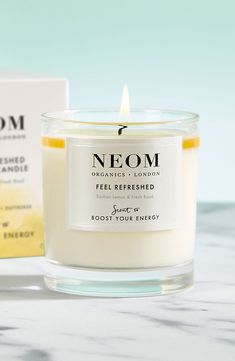 a candle that is sitting on a table next to a box with the word neom