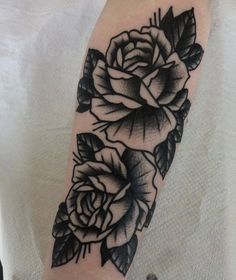 a black and white rose tattoo on the arm