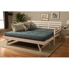 a day bed sitting on top of a wooden floor