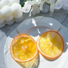 two halves of an orange on a white plate with flowers in the backgroud