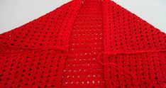 a red crocheted blanket sitting on top of a table