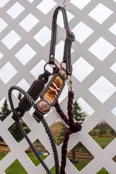 a horse bridle and reins hanging on a white fence