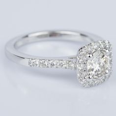 a white gold engagement ring with an oval cut diamond in the center and pave set shoulders