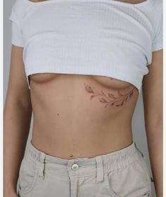 a woman's stomach with tattoos on her side and the bottom part of her body