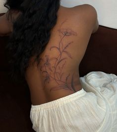 the back of a woman's body with flowers on it, and her left shoulder