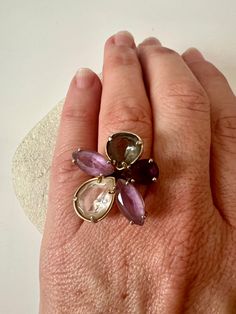 "Multi Stone Floral Ring Sterling 925. Multi Gemstone Sterling Silver 925 Ring. Amulet Ring 925. Floral 925 Israel. Floral  Such a stunning statement ring with multi gemstones, amethyst, green and purple. Contemporary in design!  Ring size : 7 Stamped : Iris ( designer) * please note all stones are in tact and no chips etc  but band I believe is a gold wash ( vermeil) over silver is worn and silver shows through I took a photo to show, however the ring is still stunning and from a frontal view l Amulet Ring, Smokey Topaz, Floral Ring, Amethyst Gem, Aqua Chalcedony, Rose Gold Pendant, 925 Ring, Gold Wash, Aquamarine Stone