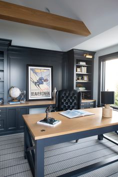 a home office with built in bookshelves, desk and leather chair by the window