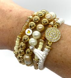 🌴 FREE SHIPPING! 🌴 Item Details: Length: approximately 7 inches Closure:  stretch Material:  Seed Beads, Pearl Beads, Heart  Charms, Tassel Charm, Gold Ball Beads, Stretch Cord Chain Style:  Beaded and Stretchable Color:  Gold White Cream Handmade 🌴  This gold bracelet stack is a fun and fashionable addition to all of your trendy outfits.  It is a gold bracelet set of five bracelets with a heart and tassel charm.  The gold and white bracelet set is a perfect summer bracelet stack.  You can mix and match any of these bracelets to stack/layer with each other or any other bracelets as well. 🌴 These bracelets are each made to adjust to any size wrist.  The beaded bracelets are stretchable bracelets.  Each bracelet is carefully handmade just for you. 🌴  Pink Palm Trees jewelry is attractiv Summer Bracelet Stack, Bracelet Stack Gold, Palm Tree Jewelry, Gold Bracelet Stack, Gold Beaded Bracelets, Bracelets Heart, Gold Bracelets Stacked, Heart Bracelets, Summer Bracelet