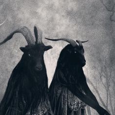 two women with long hair and horns are standing in front of a full moon behind them