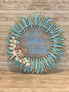 a wreath made out of pops sticks with the words we are better at the beach on it