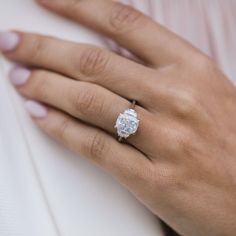 a woman's hand with a diamond ring on it