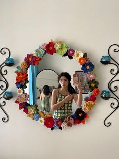 a woman is taking a selfie in front of a mirror with flowers on it