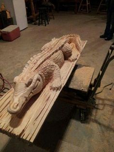 a wooden carving of an alligator on a cart