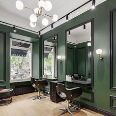 a salon with green walls and black chairs