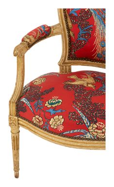 an ornately decorated arm chair with red and blue floral upholstered fabric on the back