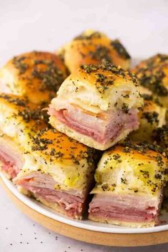 ham and cheese sliders on a plate with mustard sprinkled on top, ready to be eaten