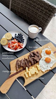 a wooden cutting board topped with meat and eggs