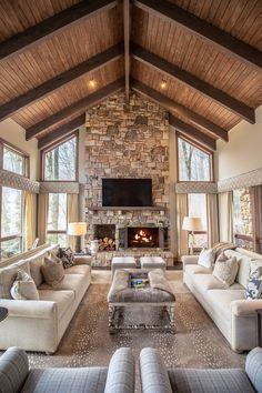 a living room filled with lots of furniture and a fire place in the middle of it