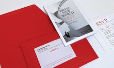 an open red envelope with a white and black business card next to it on a table