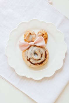 a white plate topped with cinnamon rolls covered in icing