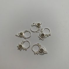 "These are soooooo pretty. Made is 925 sterling silver with tribal details, set with a grounding smokey quartz stone. The rings are all 1cm (.40\") in diameter. The wire is 20 gauge. Each piece is made BY HAND so there may be very slight differences One of the images contains numbers to specify which you would like from the drop down menu." Elegant Handmade Silver Nose Rings, Spiritual Silver Body Jewelry For Gift, Bohemian Silver Nose Rings Nickel Free, Unique Style Nickel-free Silver Nose Rings, Adjustable Sterling Silver Nose Rings, Silver Stackable Septum Ring, Silver Internally Threaded Toe Ring, Silver Stackable Round Septum Ring, Bohemian Sterling Silver Nose Rings