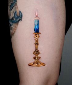 a tattoo with a candle on it's side and tattoos on the other side