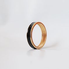 A classy ring band made in 14k solid gold with an inlay of luxurious black enamel all around the band. Available in 14K yellow gold, rose gold and white gold.Materials:- 14K solid gold- Black enamel inlay- 4.8mm bandwidth** Tippy Taste Men's are made-to-order. Please allow 3-4 week turnaround time. This ring is not resizable, please ensure ring size before purchase. ShippingDomestic: Free standard shipping within the U.S.International: Free standard shipping for orders over $200 Bespoke order: - Classy Ring, Enamel Ring, Ring Band, Black Enamel, Gold Rose, Gold Black, Precious Metals, Band Rings, Solid Gold