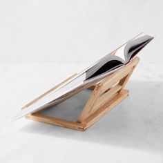 an open book sitting on top of a wooden stand