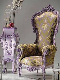 an ornate chair and side table with flowers in it