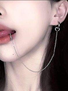 a close up of a person wearing chains on their neck and nose with the chain attached to them