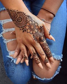 two hands with henna tattoos on them