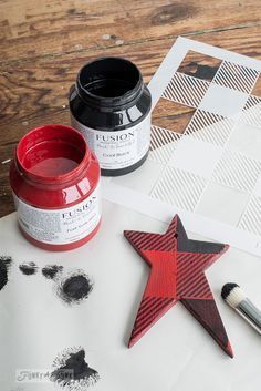 a wooden star sitting on top of a table next to some paint and a brush