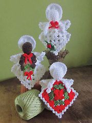 crocheted flowers hang from the handle of a refrigerator