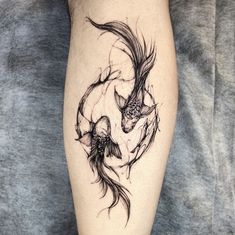 a woman's leg with a tattoo on it that has two fish in the water