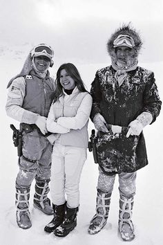 three people standing next to each other in the snow