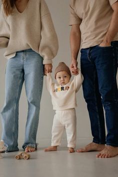 a man and woman holding hands while standing next to a small child in front of them