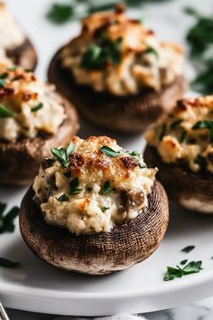 several stuffed mushrooms on a white plate with parsley