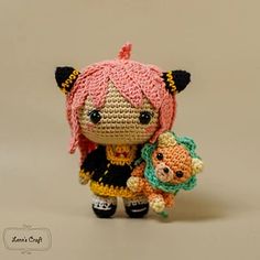 a small crocheted doll holding a stuffed animal