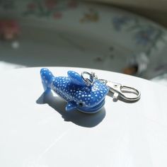 a blue whale keychain sitting on top of a white table