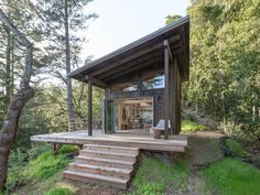 a small cabin in the woods with steps leading up to it