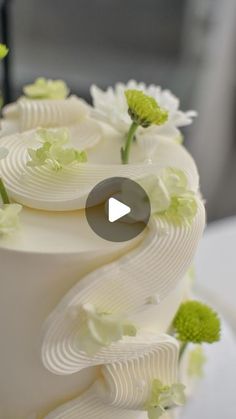 a white wedding cake with green flowers on top