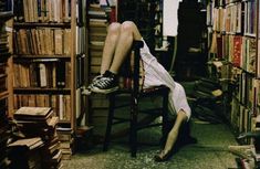 a person sitting on a chair in a room full of books