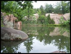 a lake surrounded by large rocks and trees