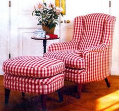 a red and white checkered chair sitting in front of a door