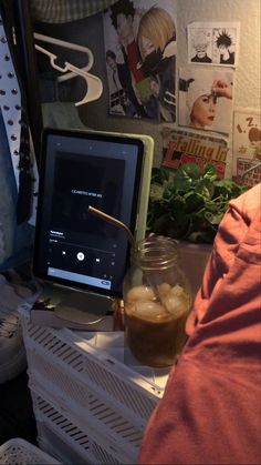 a tablet computer sitting on top of a table next to a jar of liquid and vegetables