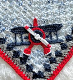 a crocheted heart with an airplane on it and the word love is written in red, white, and blue