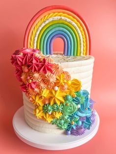 there is a rainbow cake with flowers on it